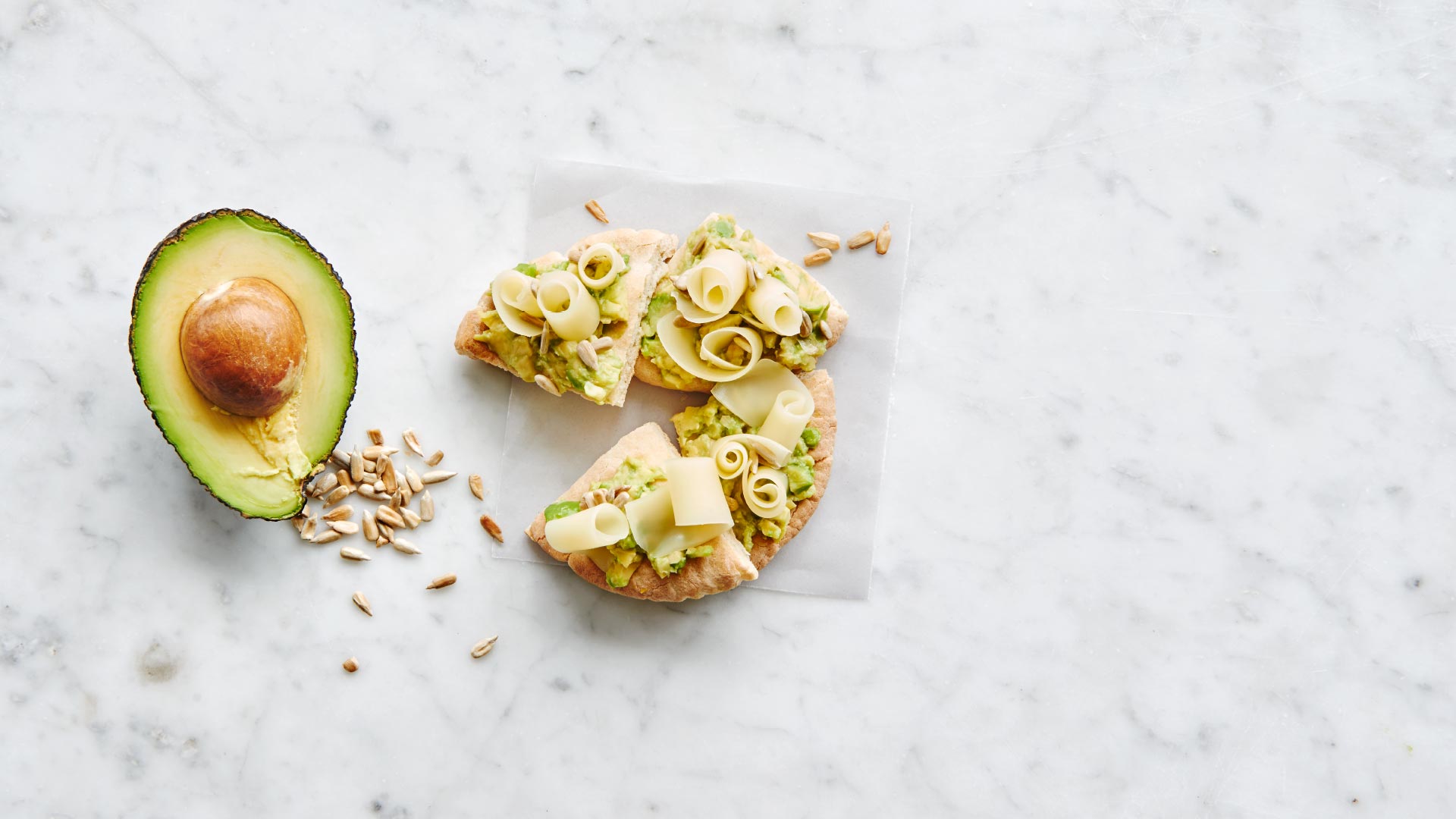 Pitta bread with smashed avocado, sunflower seeds and Emmentaler AOP curls - Emmentaler AOP Switzerl